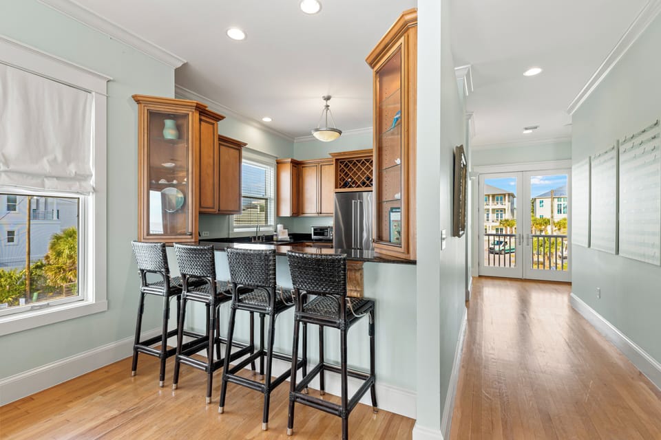 Gather around your stylish breakfast bar with rich wood cabinetry and sleek appliances, perfect for morning coffee or casual meals.