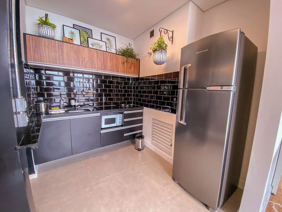 Geladeira, cooktop, microondas e utensílios domésticos disponíveis para nossos hóspedes.