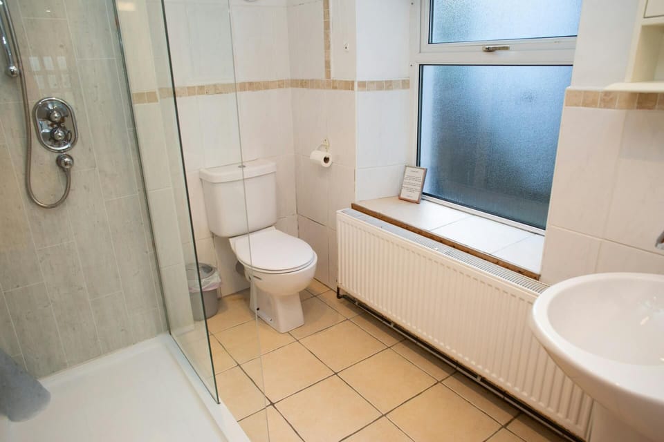 Bathroom with glass shower enclosure, toilet and sink