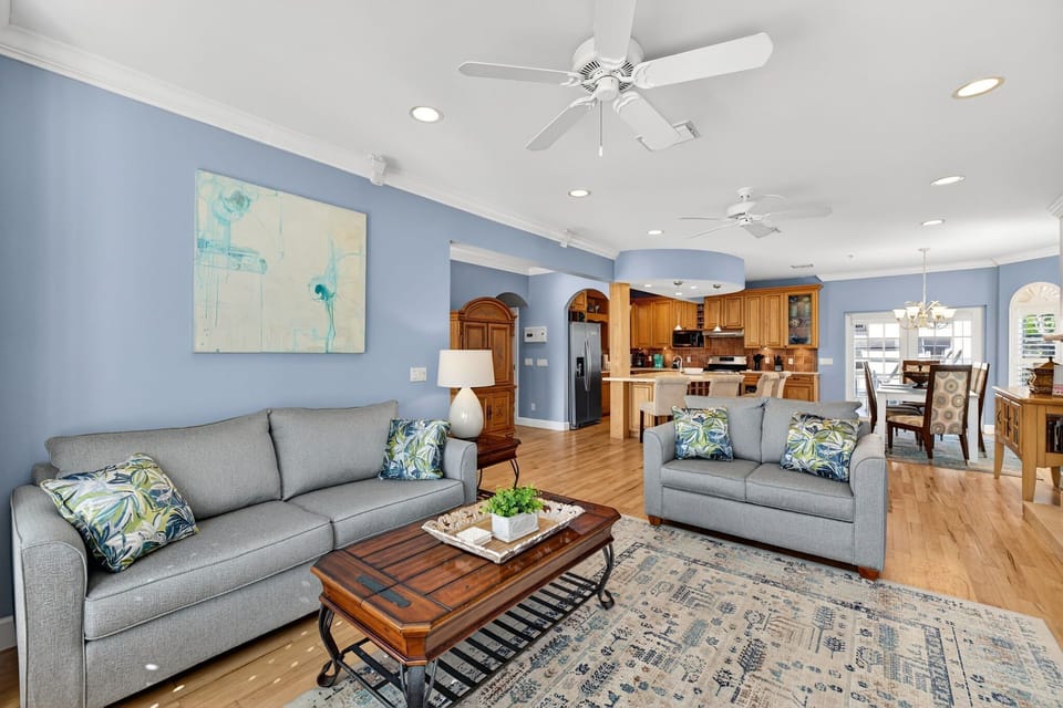 Elegant Captiva retreat featuring a spacious, light-filled living room with a fireplace, plantation shutters, and upscale coastal design.