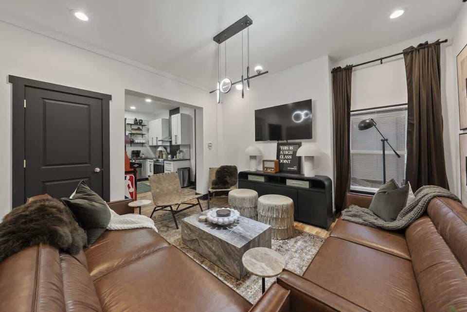 Spacious living room w/ leather sofa, fireplace & large windows for natural light