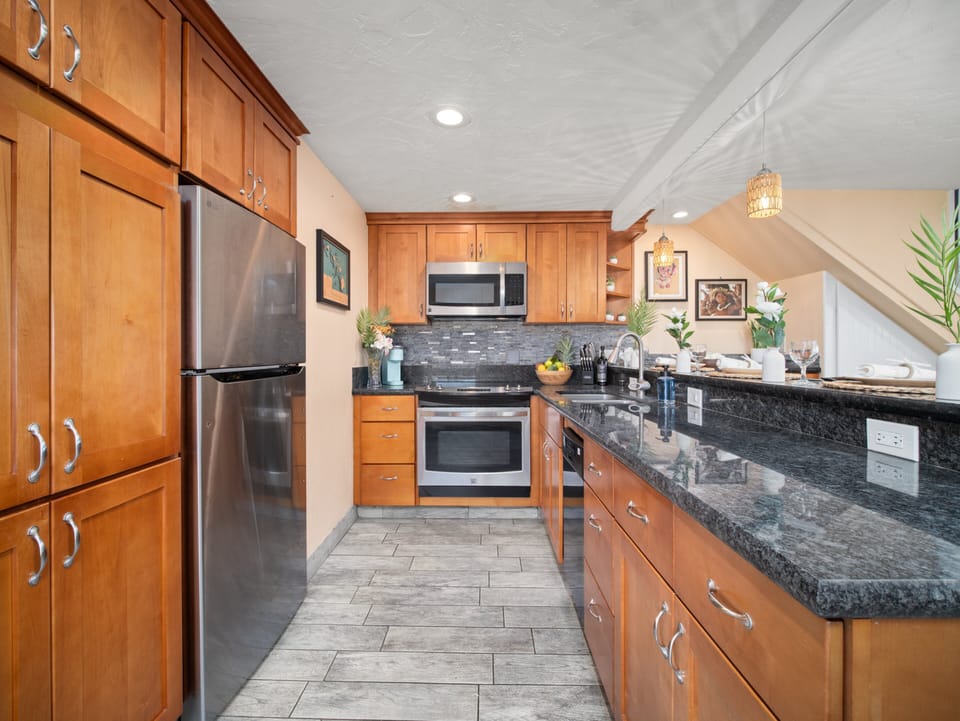Cook with ease in the fully equipped Maui kitchen featuring stainless steel appliances, granite countertops, and ample space for preparing island-inspired meals.