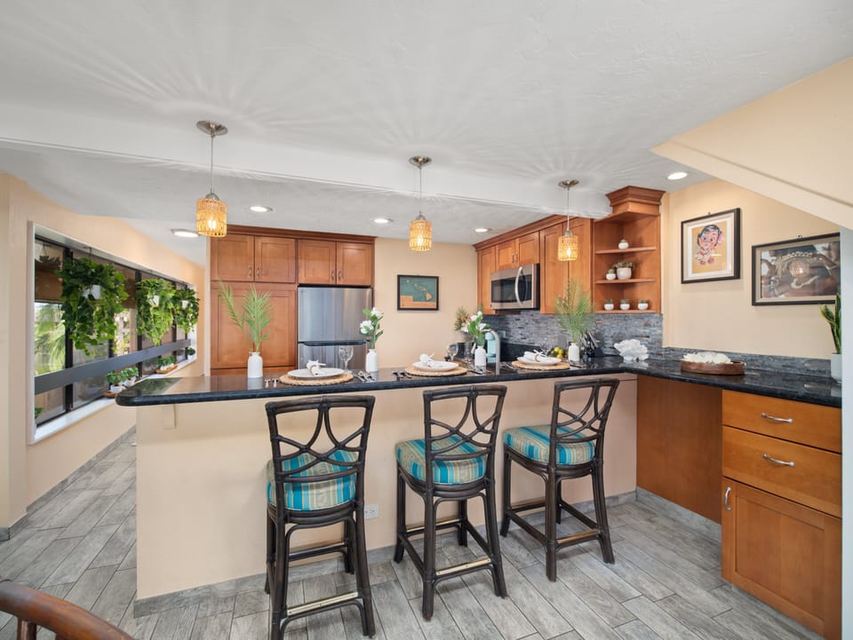 Prepare island meals in the fully equipped kitchen with granite countertops, modern appliances, and a breakfast bar—perfect for casual dining during your Maui stay.