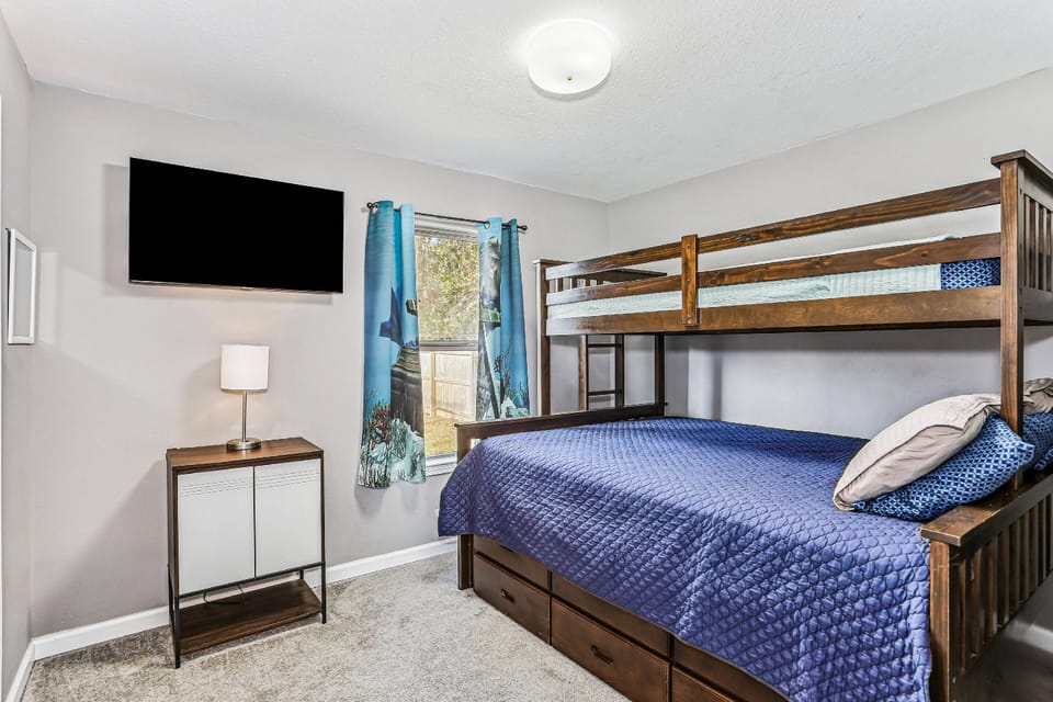 Bunk room with a queen bed on bottom and twin on top