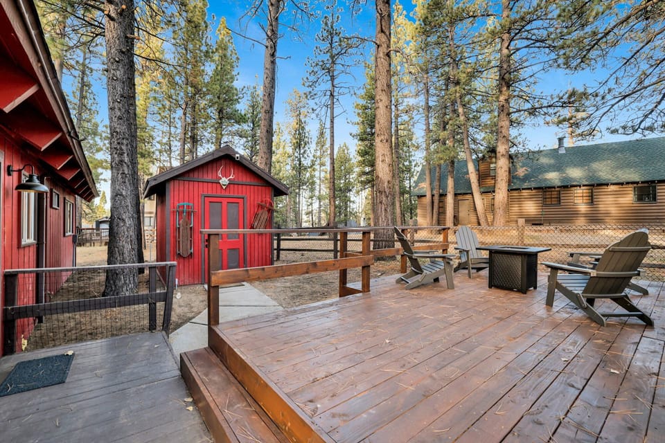 Outdoor deck with a BBQ grill, fresh mountain air, and beautiful views of the surrounding pine trees, perfect for relaxing and enjoying nature.