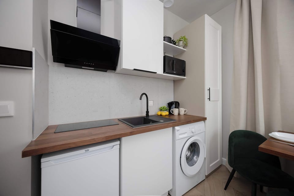 Functional kitchenette with modern appliances and a wooden countertop.