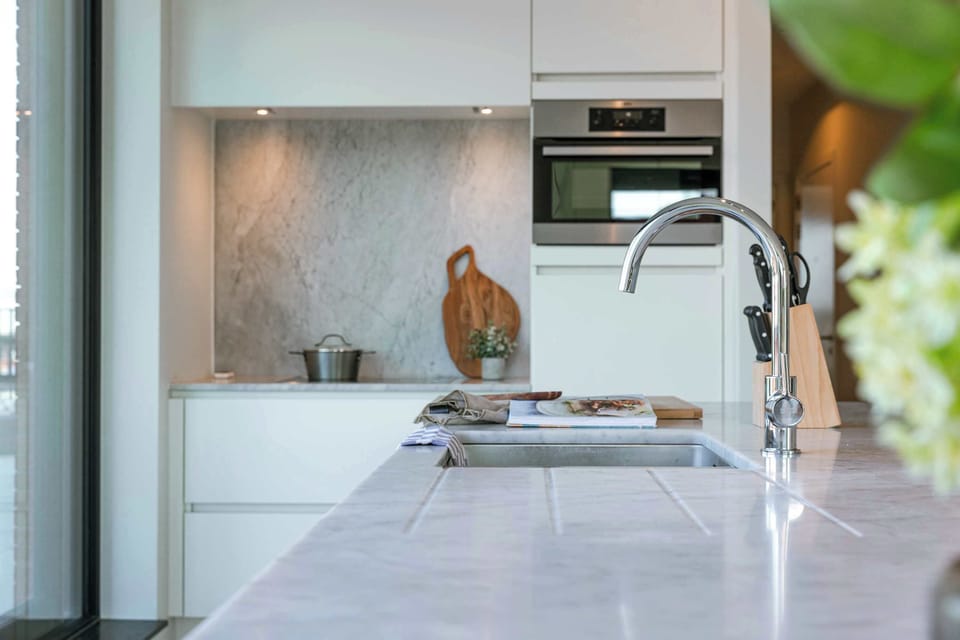 Stylish kitchen corner with marble details and natural light.