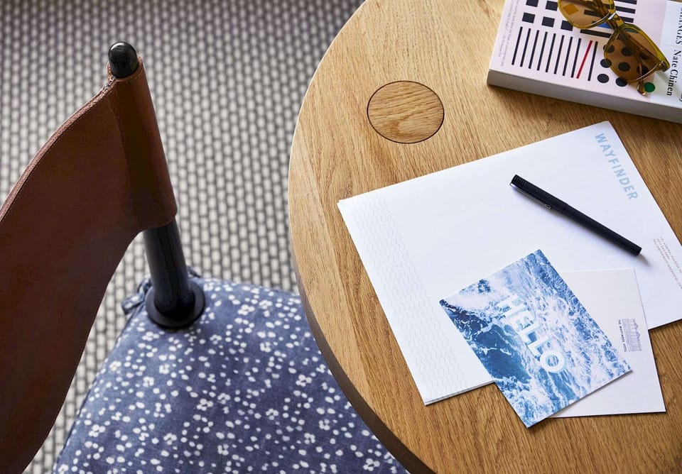 Small table setup with chair, book, and pen