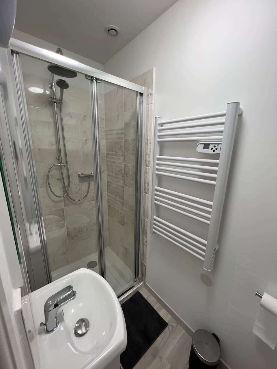 Salle de bain avec cabine de douche vitrée, vasque et sèche-serviettes — studio Le Coquet Toulouse