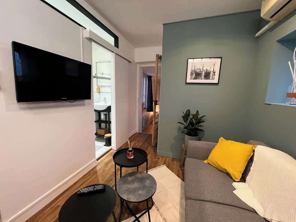 Salon avec télévision murale, étagère et canapé — Wi-Fi fibre et rangements dans le séjour du Câlin