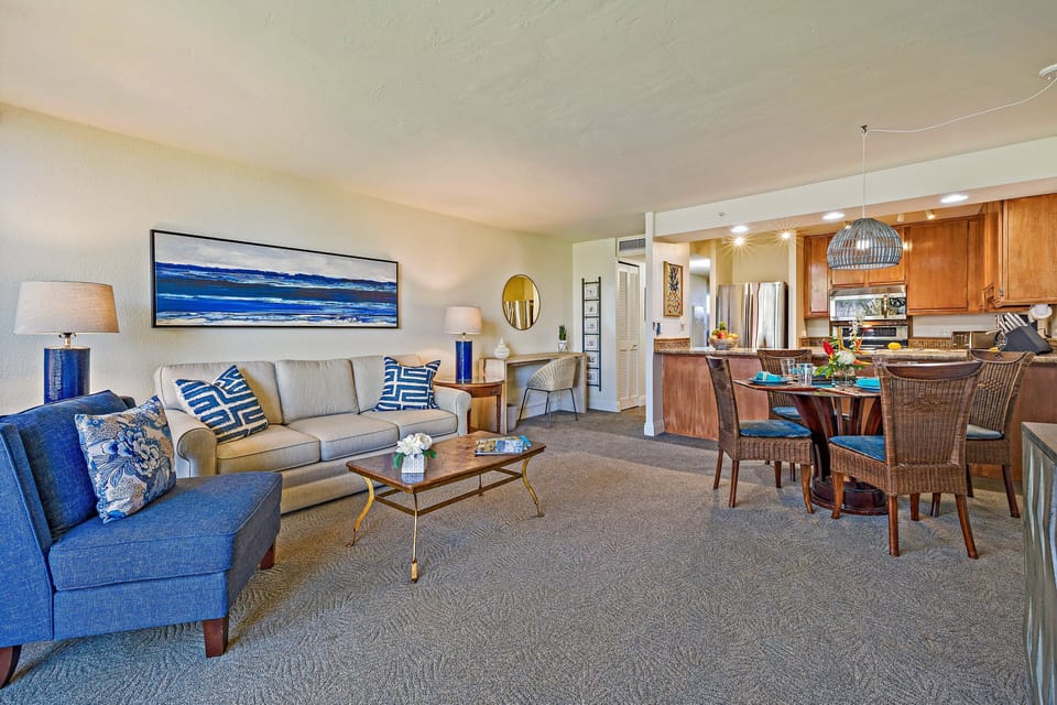 A wide, open-concept view showing the seamless flow between the coastal-style living room and the dining area.