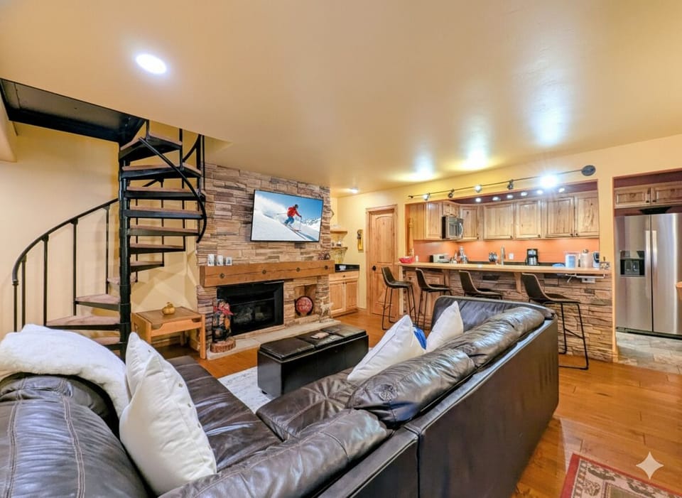 Relax into plush leather seating while the stone fireplace warms your mountain retreat, complete with a full kitchen for cozy evenings.