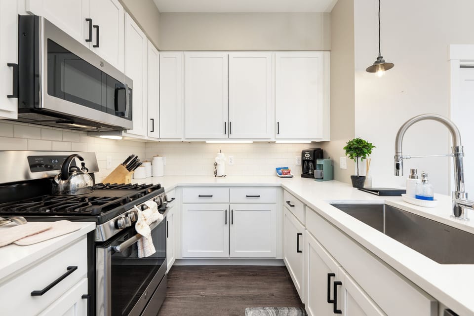 Your fully-equipped kitchen features pristine white cabinets, stainless appliances, and everything you need to create memorable meals during your stay.