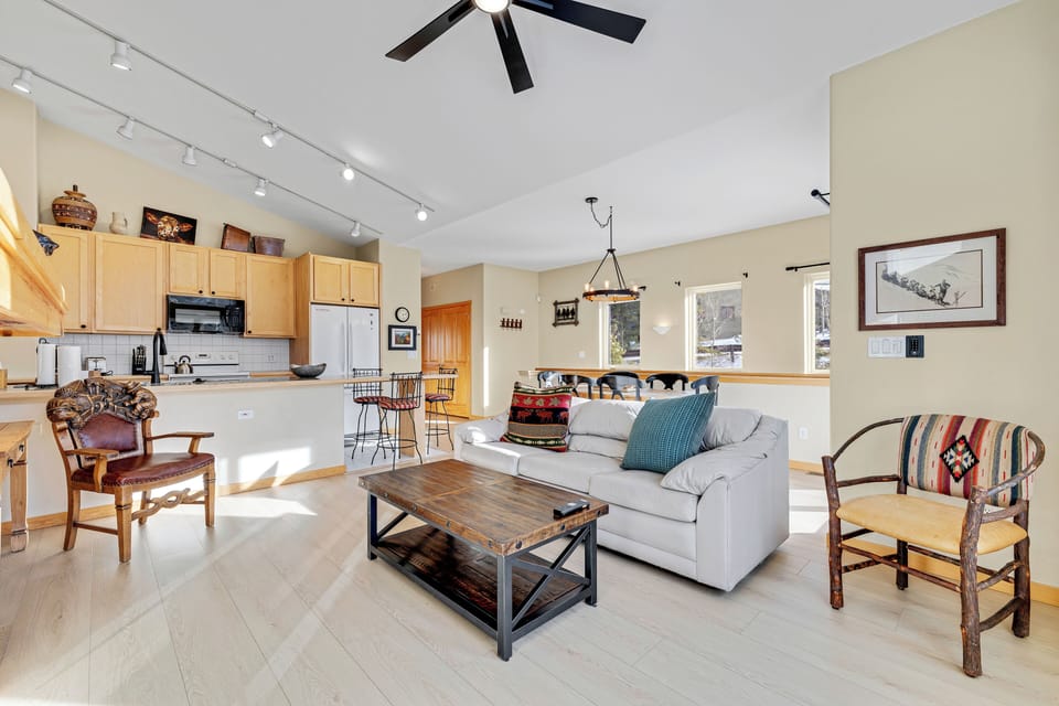 Relax in your bright open-concept living space with vaulted ceilings, modern kitchen, and cozy seating area perfect for gathering.