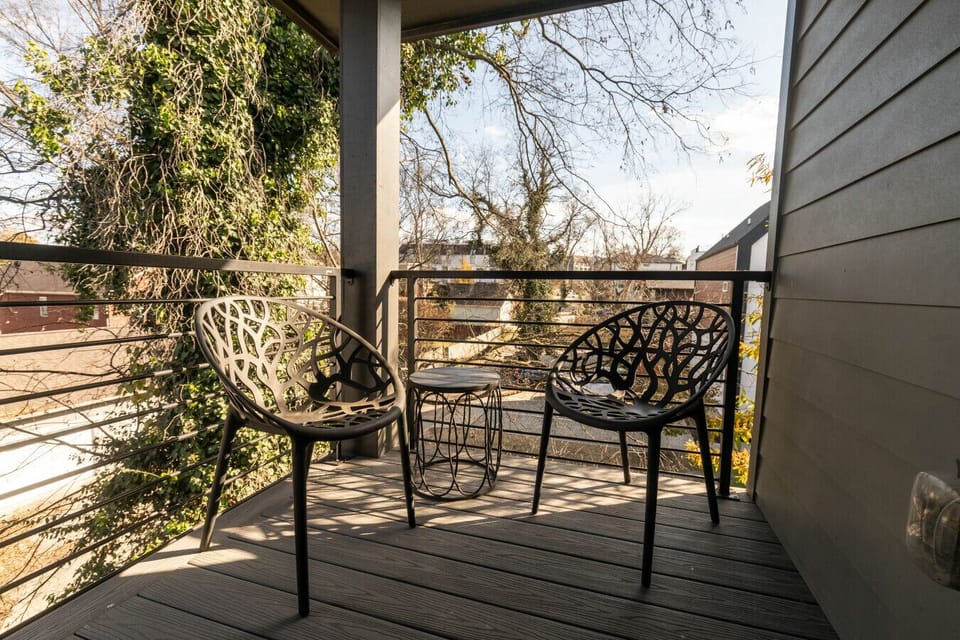 Small outdoor space with two metal chairs and a table, ideal for morning coffee with views of the surrounding neighborhood
