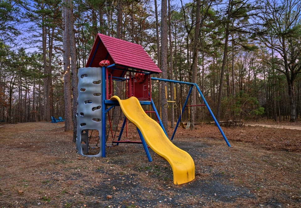 Tucked into the yard, the children’s playset offers a fun outdoor space where kids can climb, slide, and play while surrounded by nature.