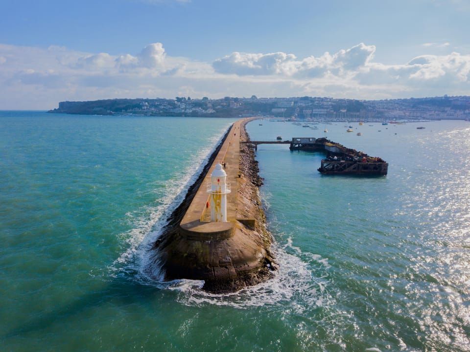 Brixham breakwater with Berry Head National Nature reserve and Brixham marina in the distance
