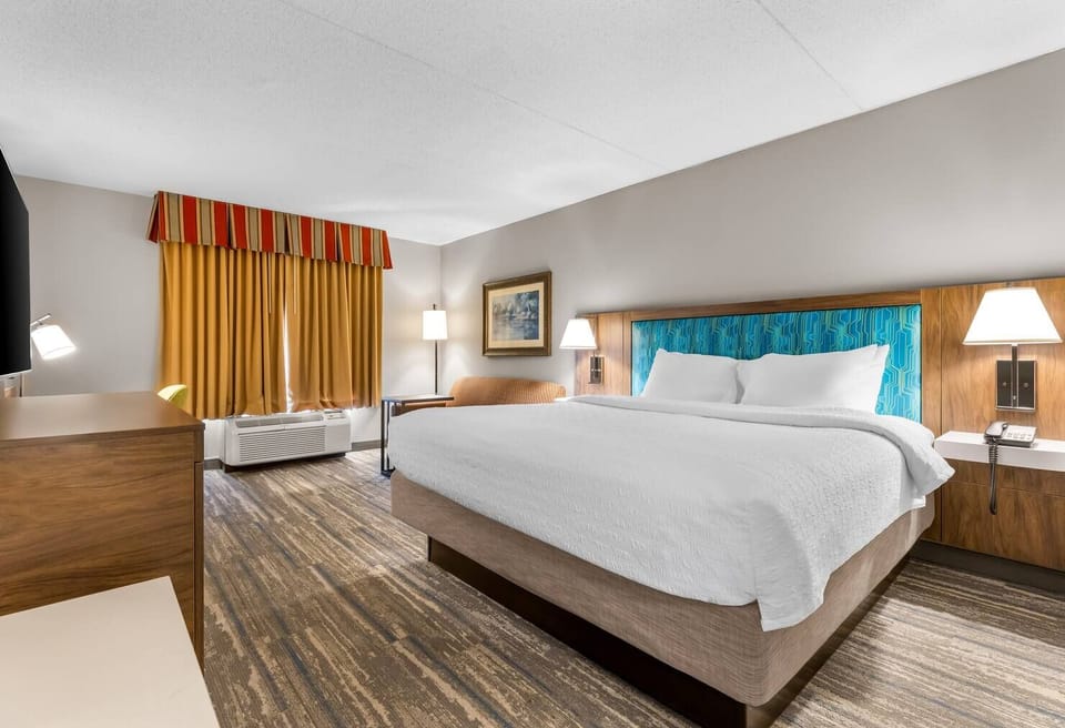 Unwind in a plush king bed with warm lighting.