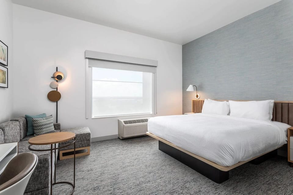 Unwind in crisp linens beside a cozy window lounge.