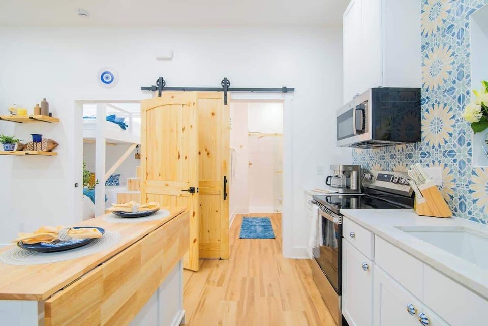 Thoughtfully designed kitchen with a spacious island, modern appliances, and Mediterranean-inspired finishes. A bright, inviting space for cooking, sharing meals, and enjoying slow mornings before heading up to the rooftop hot tub and barrel sauna.