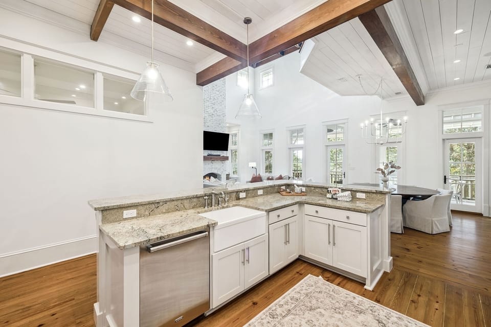 Your gourmet kitchen opens to a bright living space with soaring ceilings and rustic beams, perfect for cooking and entertaining together.