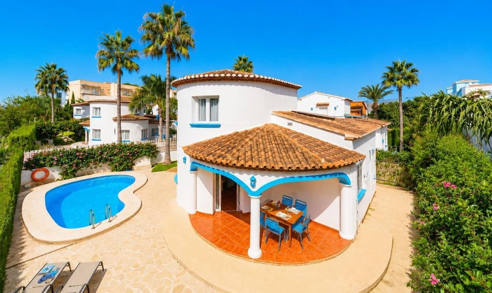 Mediterranean villa with an outdoor dining patio and swimming pool.