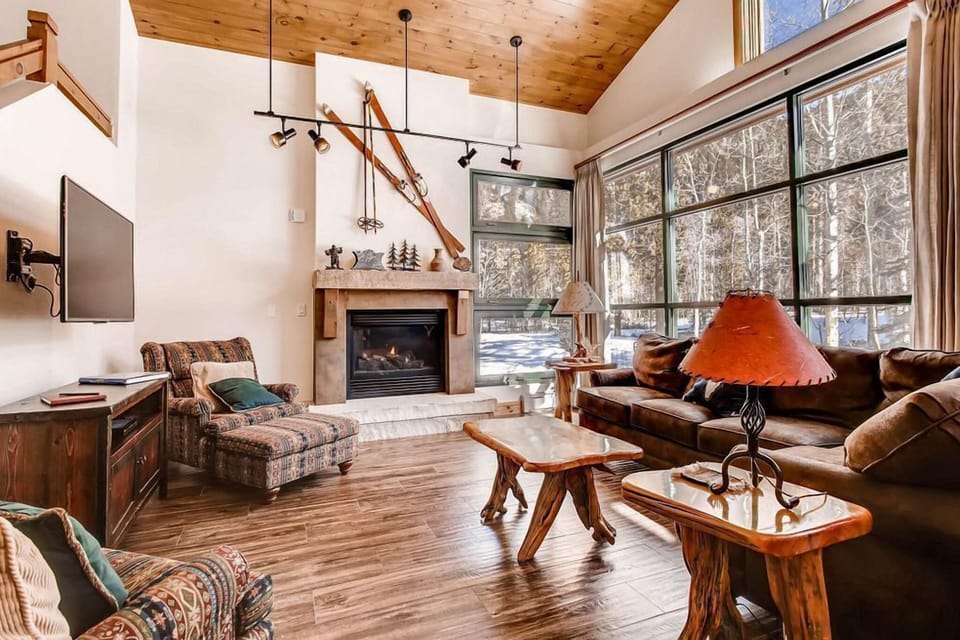 Step into this inviting living space where natural light floods in through expansive windows, creating a serene atmosphere perfect for cozy evenings by the fireplace after a day on the slopes.