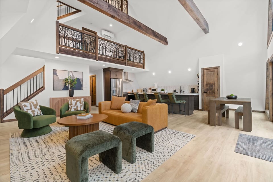 Open concept living with vaulted ceilings, cozy seating, and a loft above