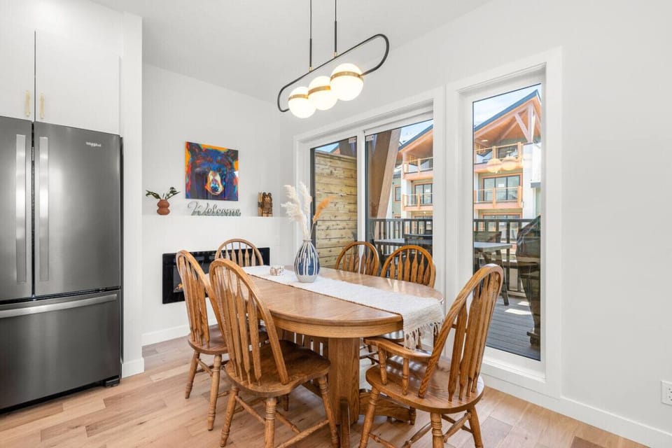 Dining area for six, perfectly set beside a warm and inviting fireplace.