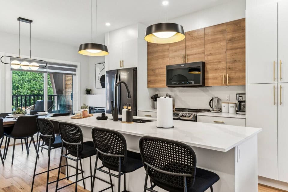 This stylish full kitchen features a spacious island bar with seating for four, perfect for casual dining and entertaining while preparing meals.