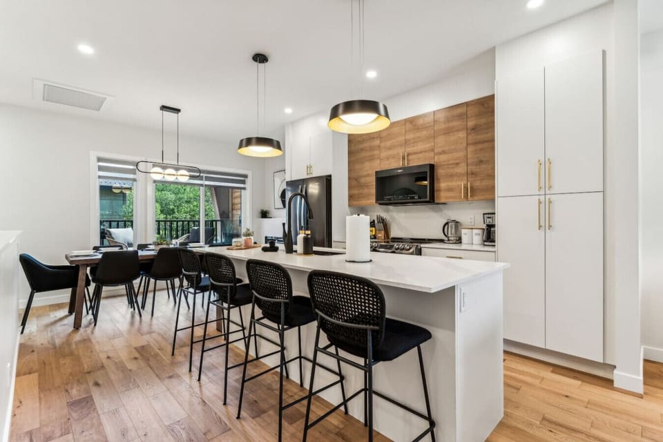 This stylish full kitchen features a spacious island bar with seating for four, perfect for casual dining and entertaining while preparing meals.