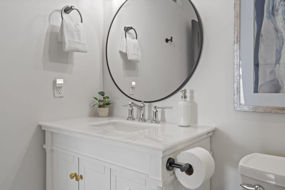 Elegant ensuite with modern finishes and round mirror