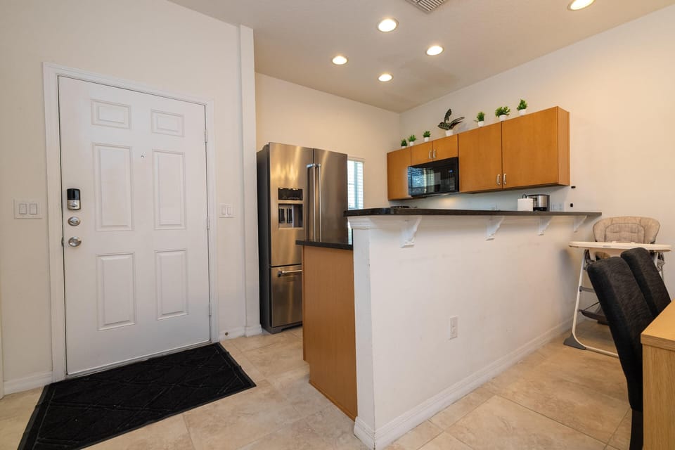 Modern kitchen with stainless steel appliances and breakfast bar seating