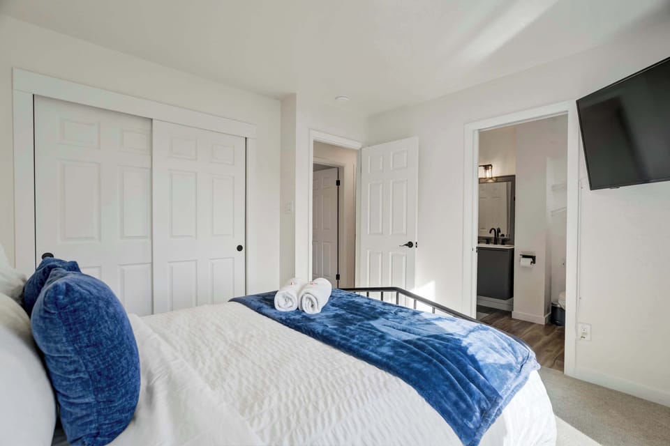 This spacious sleeping area includes a large closet and neutral decor for a peaceful atmosphere. The combination of comfortable bedding and a functional layout provides a welcoming retreat for guests.