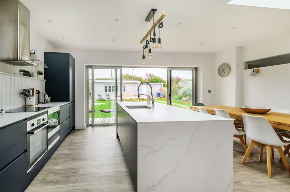 Modern open plan kitchen and dining area with garden access