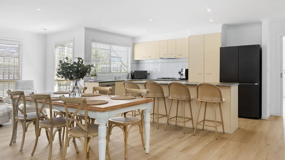 Dining table and breakfast bar providing plenty of seating for meal times