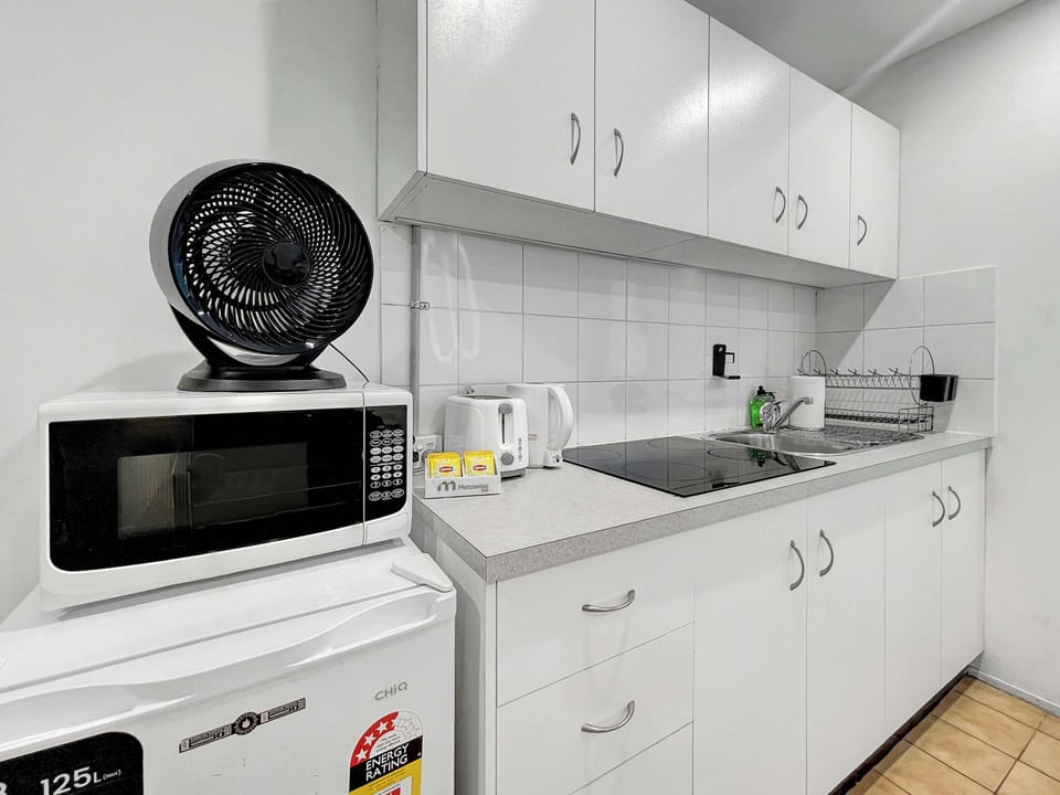 Well-equipped kitchen area featuring microwave, cooktop, and generous storage space.