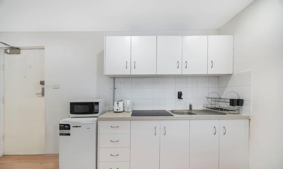Neat and functional kitchenette with ample cabinetry and essential appliances for convenient meal preparation.