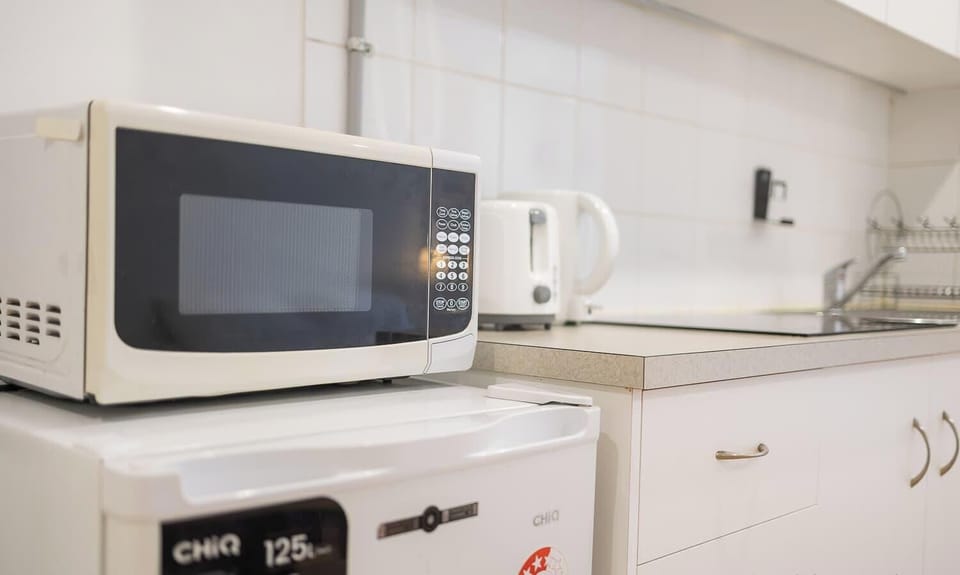 Microwave and kettle setup for quick and easy meal preparation.