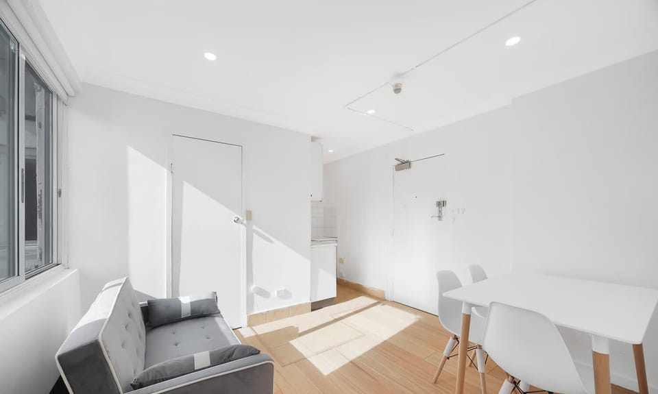 Open-plan living space with a dining table and a comfortable sofa that converts into a sofa bed, perfect for additional guests.