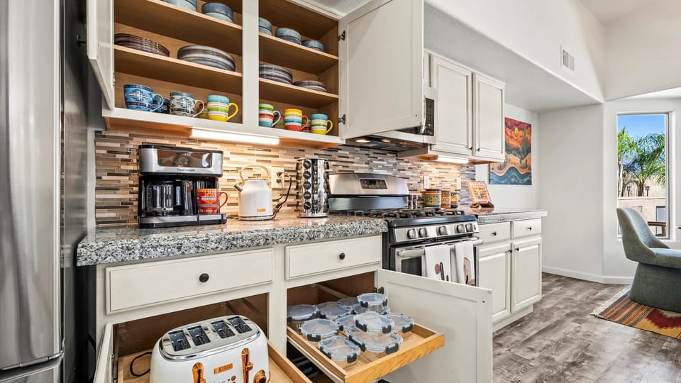 Fully stocked kitchen with cookware, dishes, and essentials