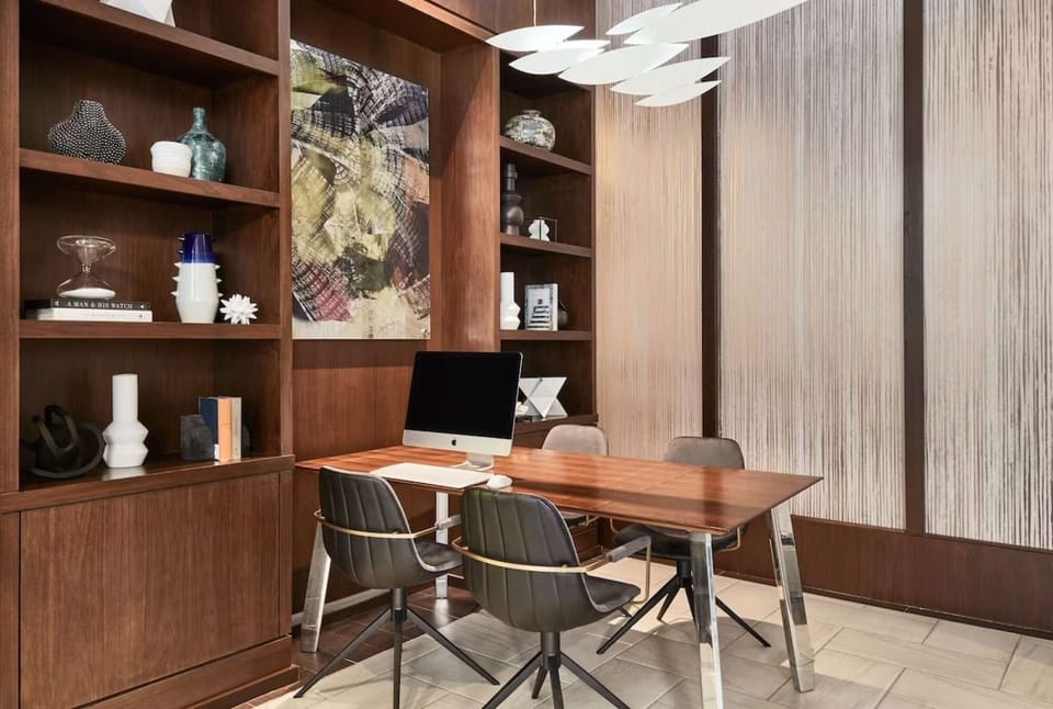 Business center with computer, chairs, and wood shelves