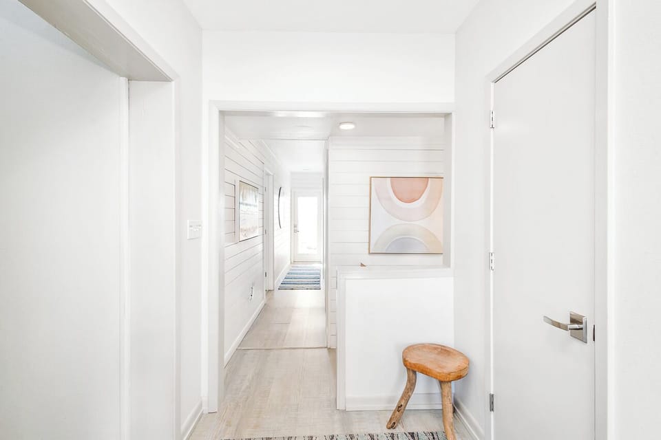 Step into your serene hallway where soft natural light flows through, creating a peaceful transition between spaces in your coastal retreat.