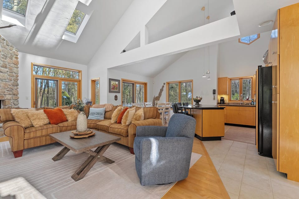 Unwind in your spacious living area with vaulted ceilings, natural light streaming through skylights, and forest views surrounding you.