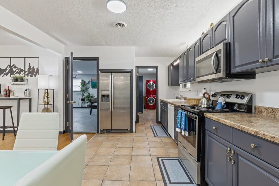 The heart of the home features everything you need to cook, clean, and recharge, with the bold red laundry set tucked just around the corner.