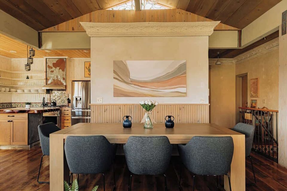 Gather around your spacious dining table where warm wood meets modern comfort, perfect for memorable meals beneath soaring cathedral ceilings.