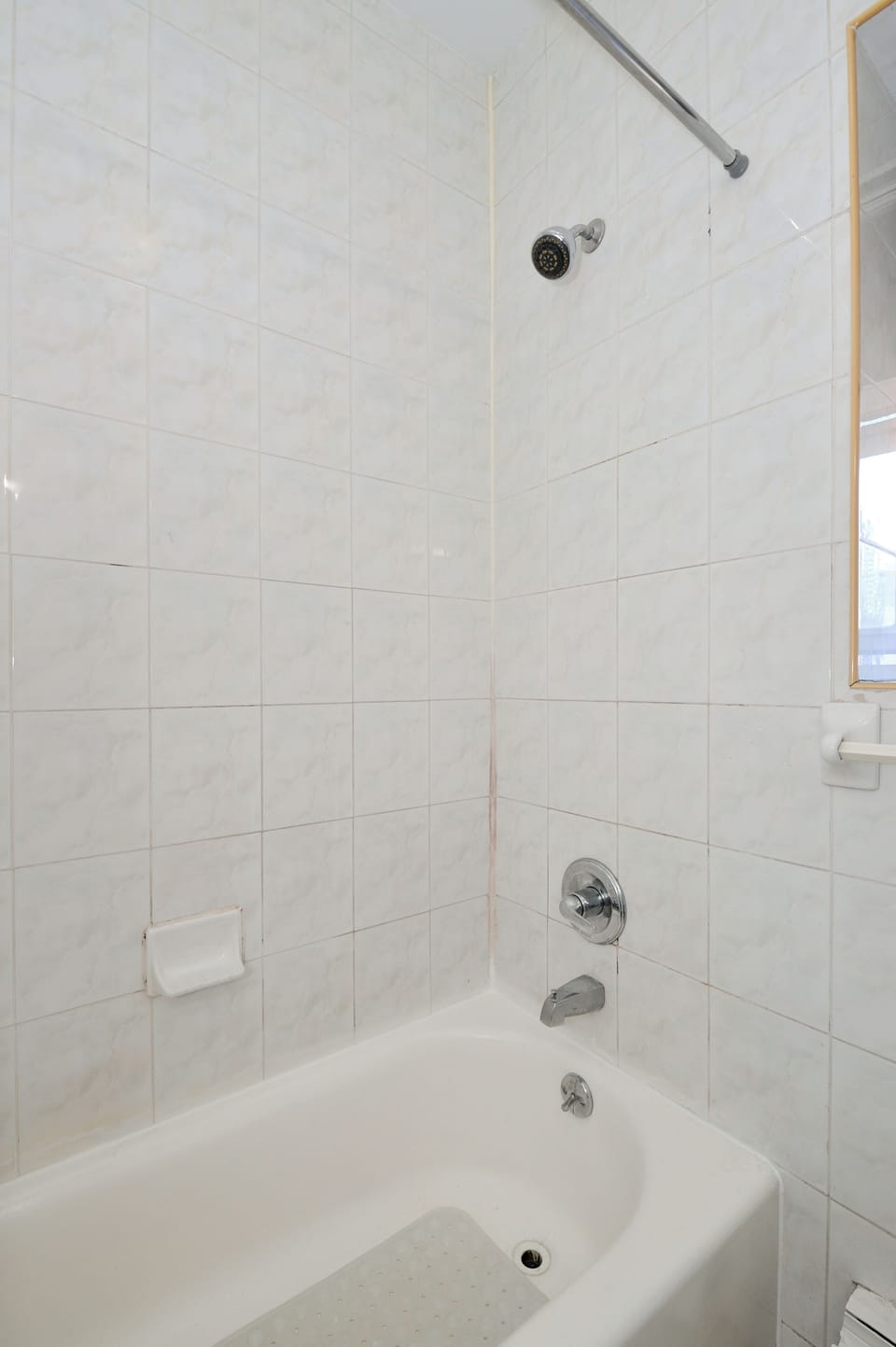 Your pristine bathroom features a spacious tub-shower combo with gleaming white tiles, perfect for relaxing after your adventures.