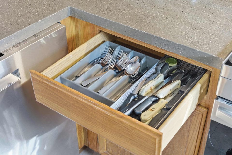 Easy-access cabinet with cutlery and dining essentials.