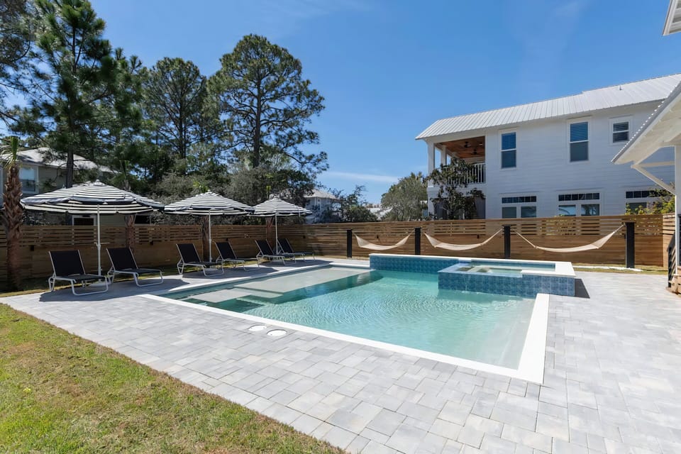 Backyard escape featuring hammocks, loungers, and sparkling water.