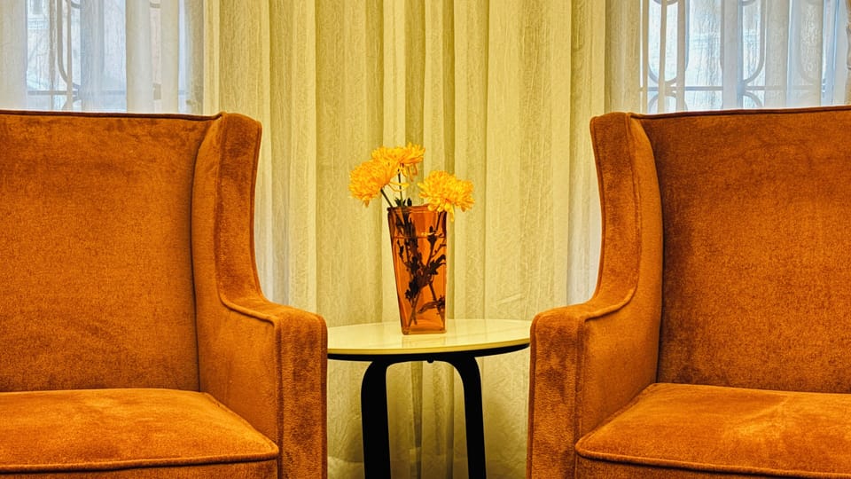 A cozy seating nook with plush armchairs and a charming side table.